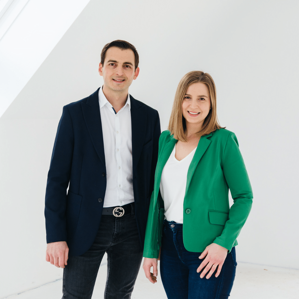 Lisa und Dominic Lorenz, Gründer der Rendite Boutique nebeneinanderstehend vor einem hellen Hintergrund.